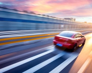 Car driving on freeway at sunset, motion blur full speed