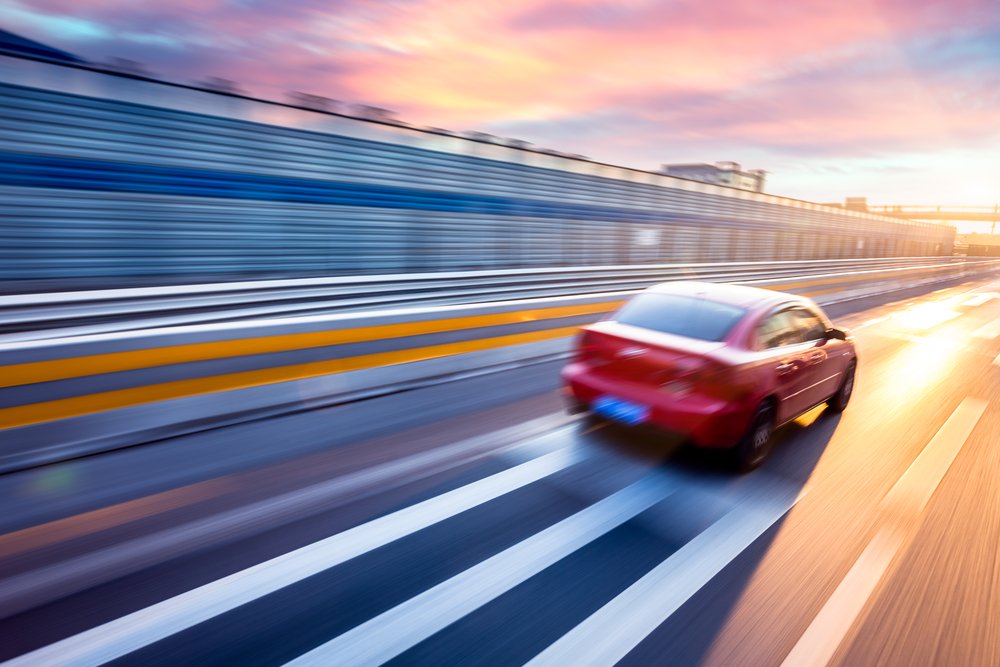 Car driving on freeway at sunset, motion blur full speed