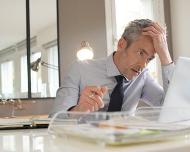 Stressed,Businessman,Working,In,Contemporary,Office