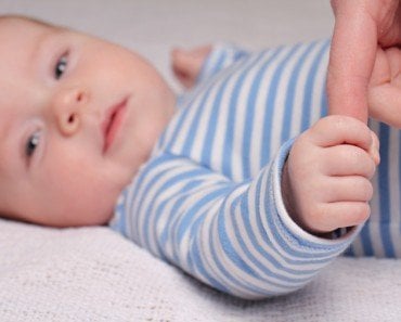 Baby fist holding finger