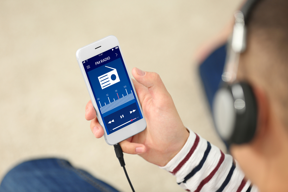 Man listening to radio on mobile phone indoors - Image( Africa Studio)s