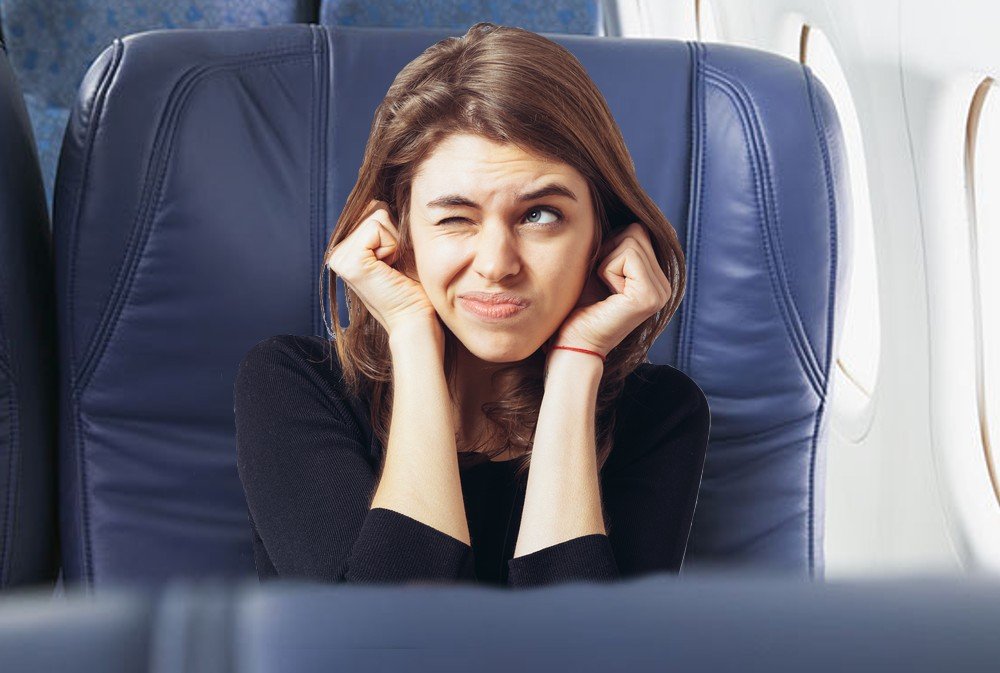 long-haired beautiful young brunette woman covering her ears with her hands, isolated on a white background