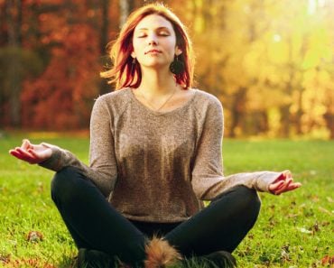 Young woman Zen meditate in park.