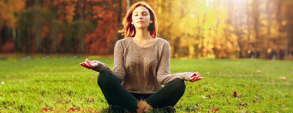 Young woman Zen meditate in park.