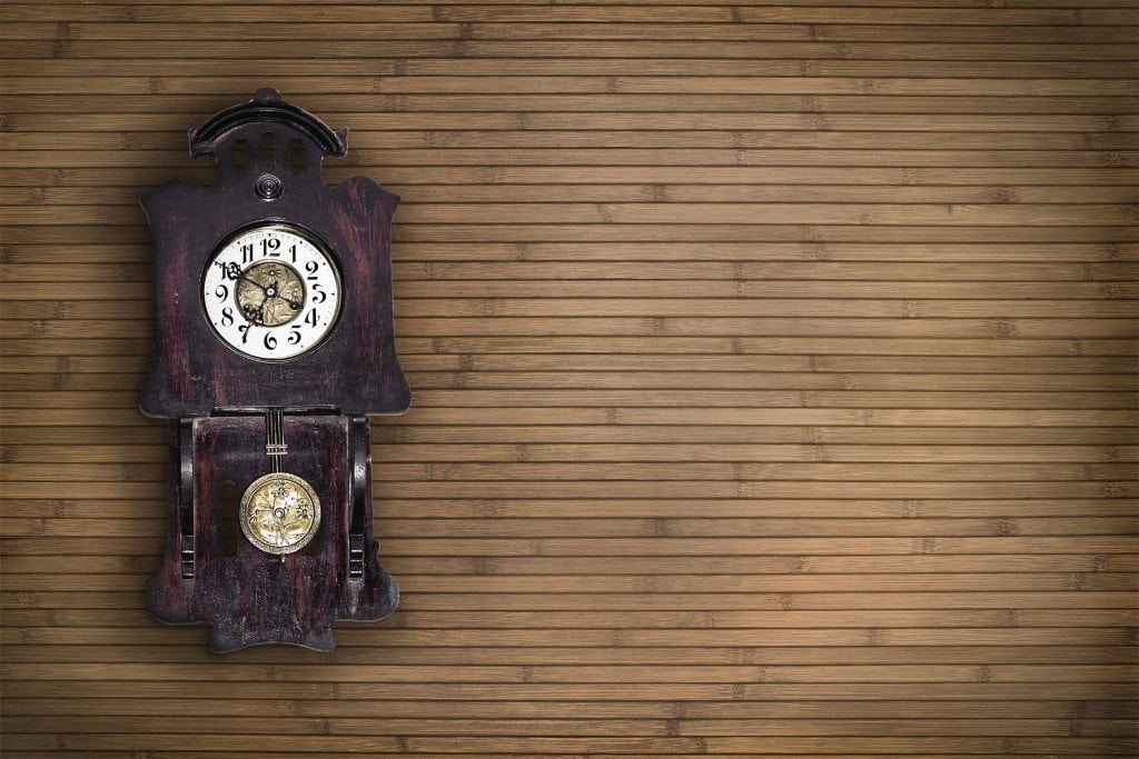 old pendulum clock on the background of wooden wall Tillottamas