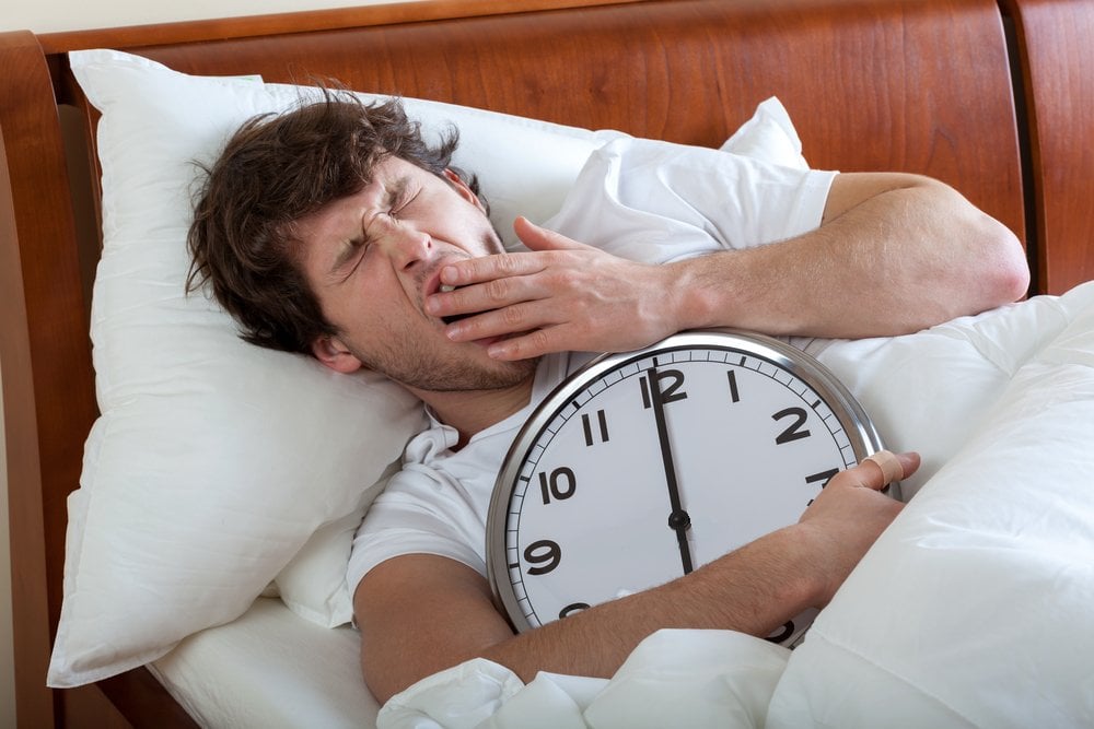 Man holding a big clock and waking up