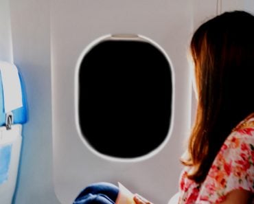 woman in airplane window night dark sky