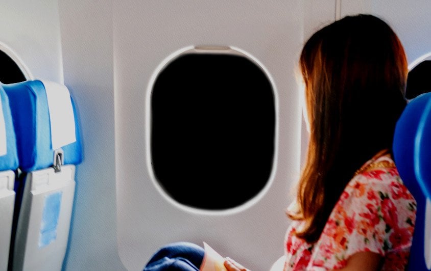 woman in airplane window night dark sky