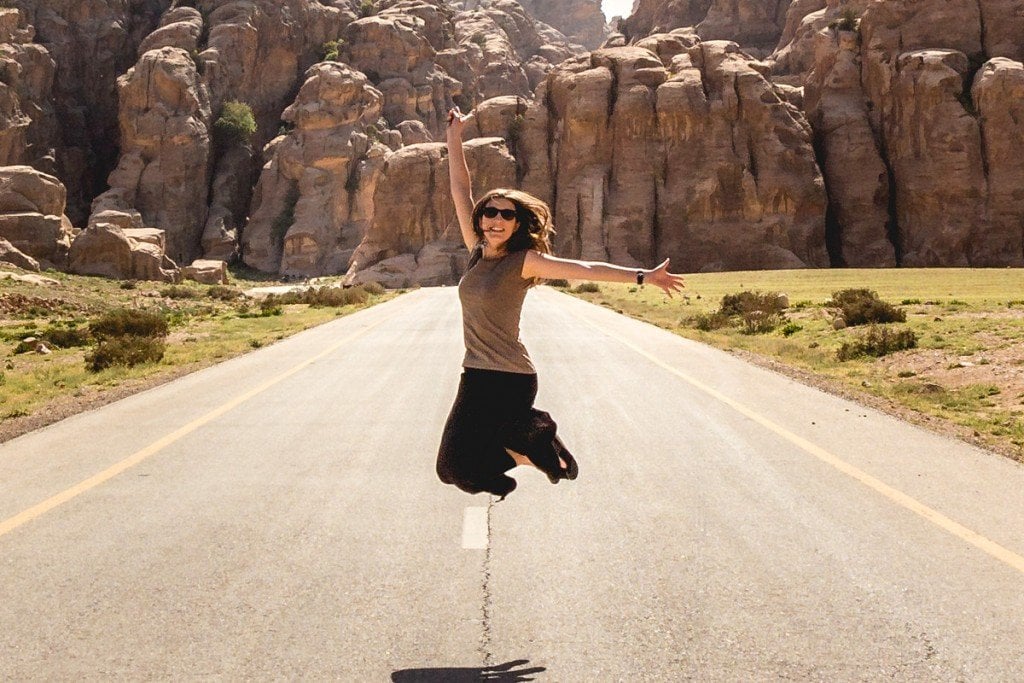 Woman jumping in midle of road