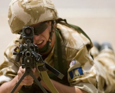 A British soldier aims a LMG