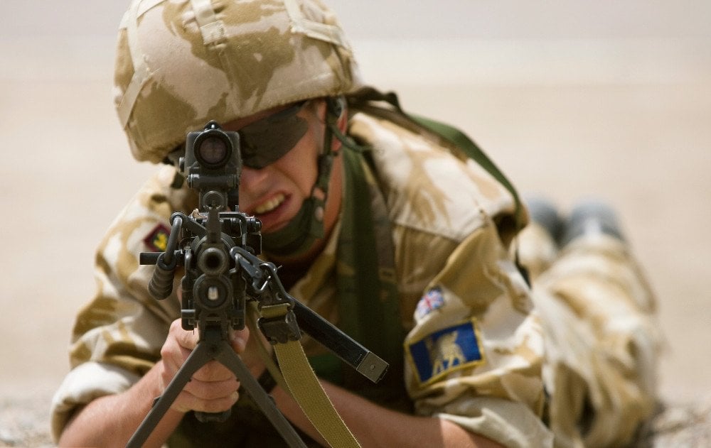 A British soldier aims a LMG
