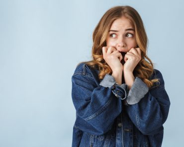 Attractive scared young girl standing isolated over white background, screaming - Image( Dean Drobot)s