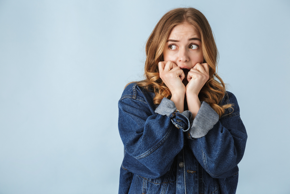 Attractive scared young girl standing isolated over white background, screaming - Image( Dean Drobot)s