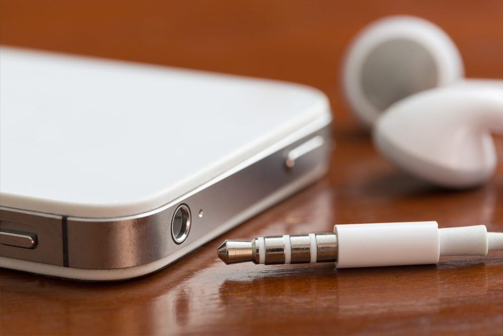 Close-up of a smartphone, earbuds, jack and port on a table with shallow depth of field - Image(David Smart)s