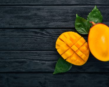 Mango. Tropical Fruits. On a wooden background. Top view. Copy space. - Image( YARUNIV Studio)s