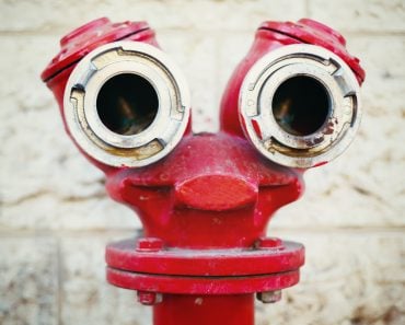 Red old fire hydrant on a street, looking like a face. Instagram style. Pareidolia. - Image(DG Stock)s