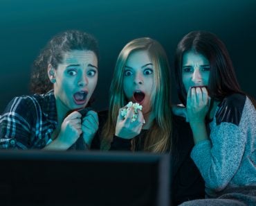 Teenage girls watching horror movie with popcorn - Image(iko)S