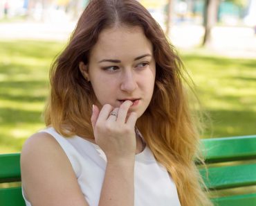 Young woman is biting her nails in the park - Image(retoncy)s