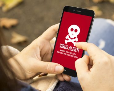 security mobile concept woman holding a 3d generated smartphone with virus alert on the screen. Graphics on screen are made up. - Image(Georgejmclittle)s
