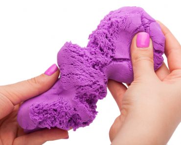 Close-up of a photo in the hands of kinetic sand on a white background - Image(Tsyb Oleh)s