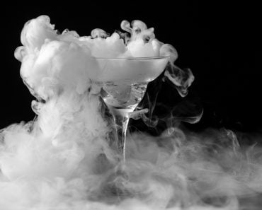Closeup glass with white fog at dark background. Chemical reaction of dry ice with water. - Image( Andrei Mayatnik)s
