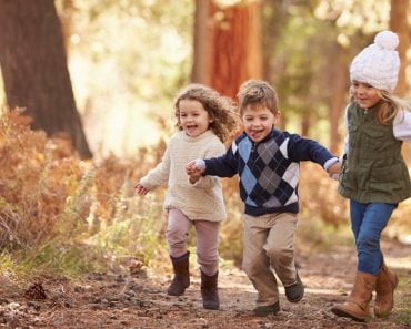 Group Of Young Children Running Along Path In Autumn Forest - Image(Monkey Business Images)s