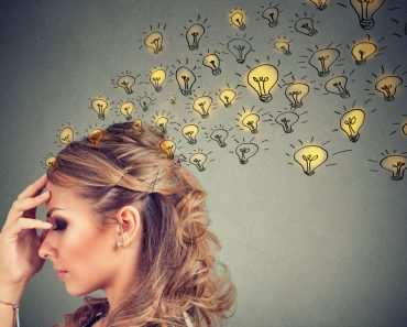Young woman thinking with concentrated having many ideas with backdrop of burning lightbulbs. - Image(pathdoc)s