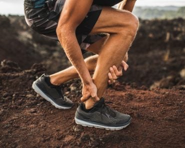 Achilles injury on running outdoors. Man holding Achilles tendon by hands close-up and suffering with pain( Breslavtsev Oleg)s