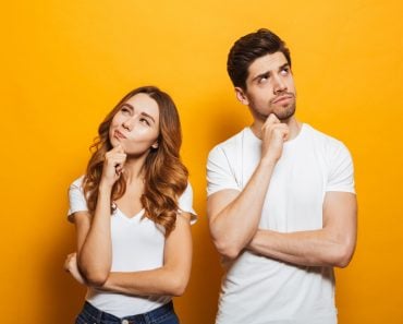 Image of happy young people man and woman in basic clothing thinking and touching chin while looking aside( Dean Drobot)S