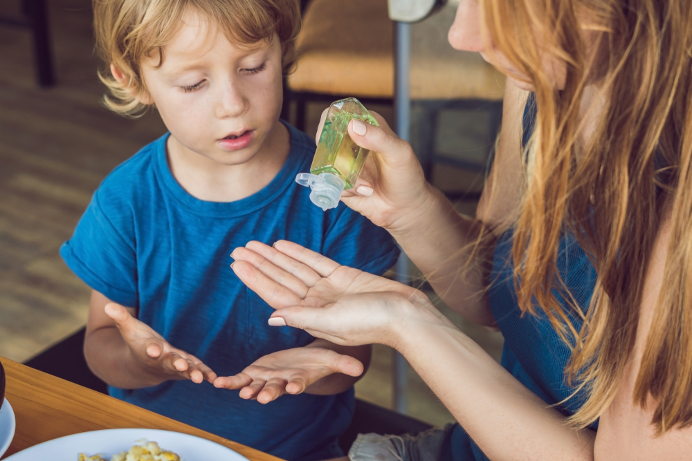 Mother and son using wash hand sanitizer gel in the cafe. - Image( Elizaveta Galitckaia)s