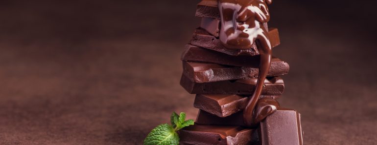 melted chocolate pouring into a piece of chocolate bars with green mint leaf on a table - Image( Dima Sobko)s