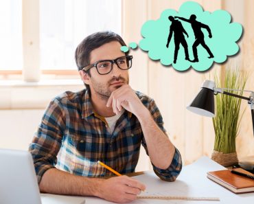 Waiting for inspiration. Thoughtful young man holding hand on chin and looking away while sitting at his working place - Image( G-Stock Studio)s
