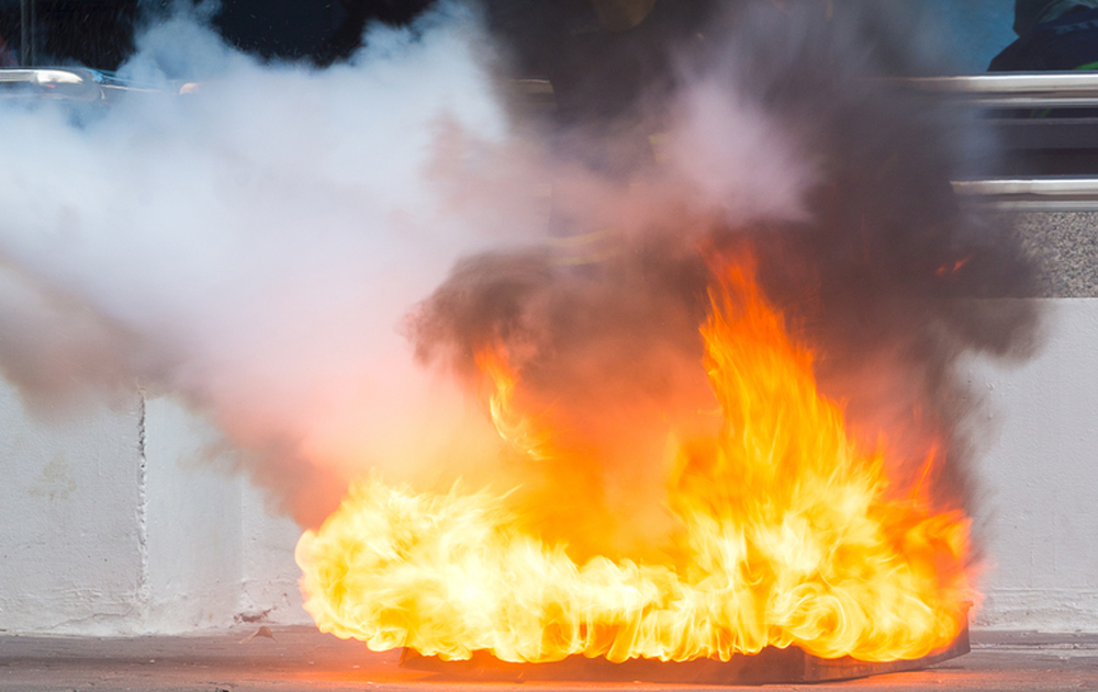 Instructor showing how to use a fire extinguisher on a training fire(sod tatong)s