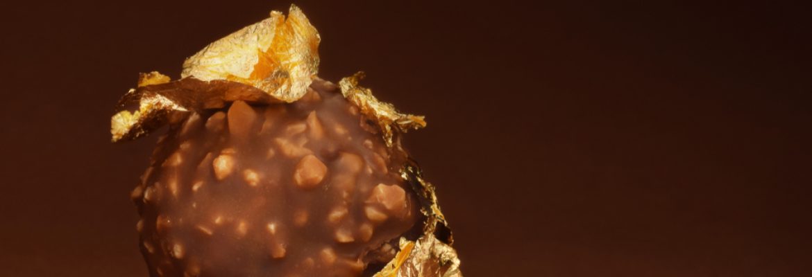 Chocolate praline with edible gold on brown dark background low key(igra.design)s