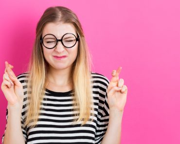 Young woman crossing her fingers and wishing for good luck(TierneyMJ)s