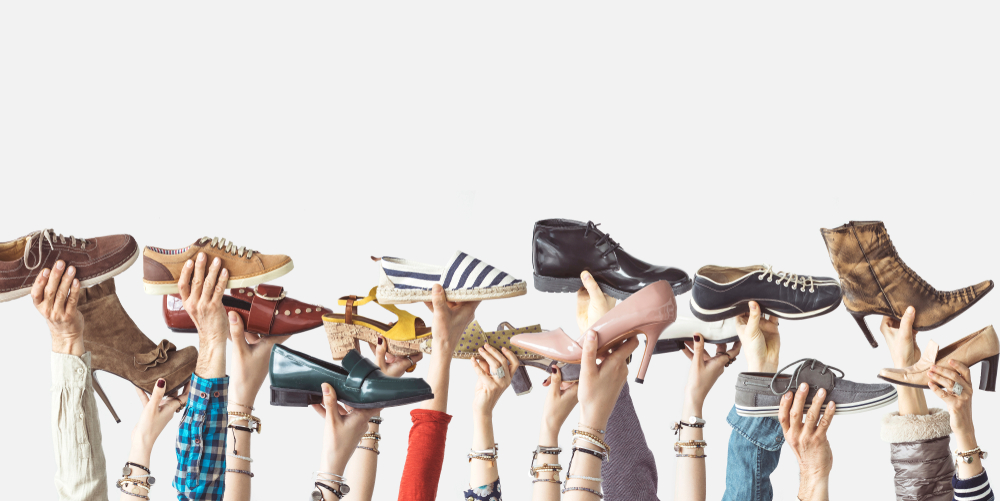 Hands holding different shoes on isolated background(sebra)s