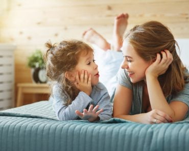 Happy family mother and child daughter play and laughing in bed(Evgeny Atamanenko)s