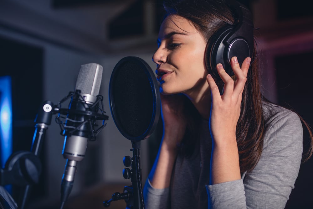 Close up of female vocal artist singing in a recording studio(Jacob Lund)s