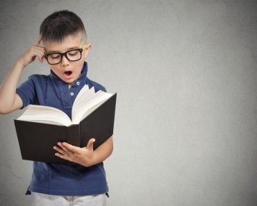 closeup portrait child with glasses reading book(pathdoc)s