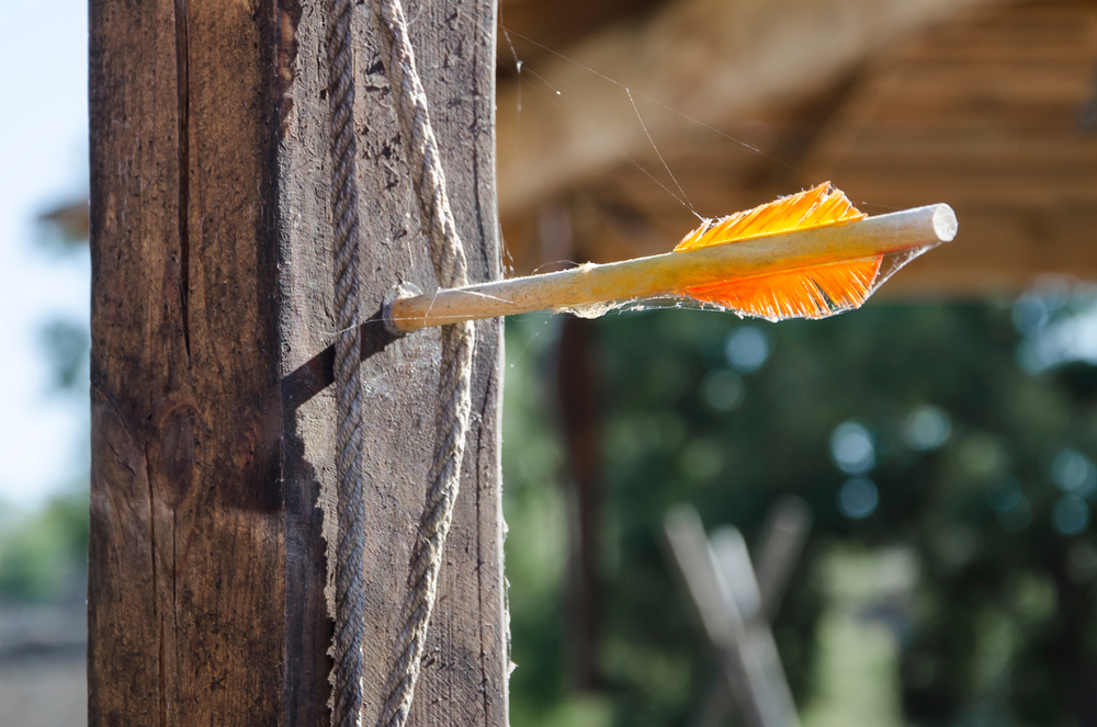 one arrow with yellow feathers stuck in a wooden fence(sobolicha11)s