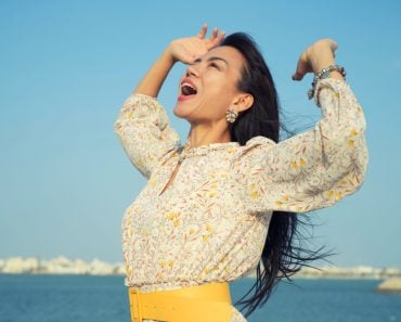 Beautiful Asain woman yelling to sky with hands open in the air over blue sea(Jantira Namwong)s