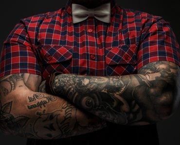 Portraite of brutal hipster with tattooes on his hand dressed in red shirt and bow tie(FXQuadro)S