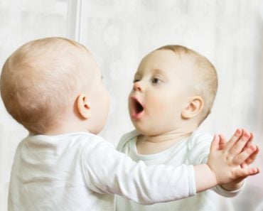 Ten month boy stands before the mirror(serg_dibrova)s