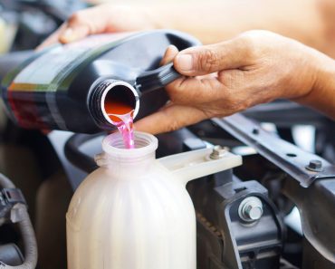 male hand filling car cooling system with coolant(SiNeeKan)s (2)