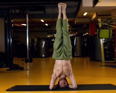 Shirshasana pose. A man practising yoga doing a headstand