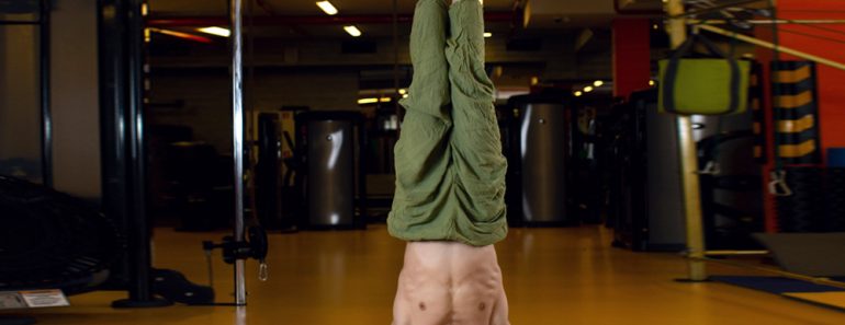 Shirshasana pose. A man practising yoga doing a headstand