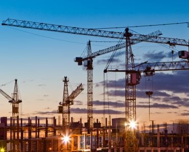 Silhouettes of tower cranes against the evening sky. House under construction. Industrial skyline(Oleg Totskyi)s