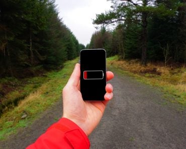 A person holding a phone in their hand with dead battery(Timothy Dry)s