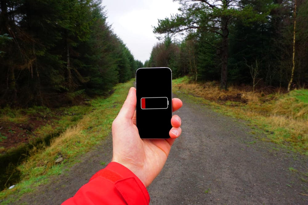 A person holding a phone in their hand with dead battery(Timothy Dry)s