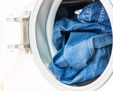 Open door in washing machine with jeans inside close up(Tommy Lee Walker)S